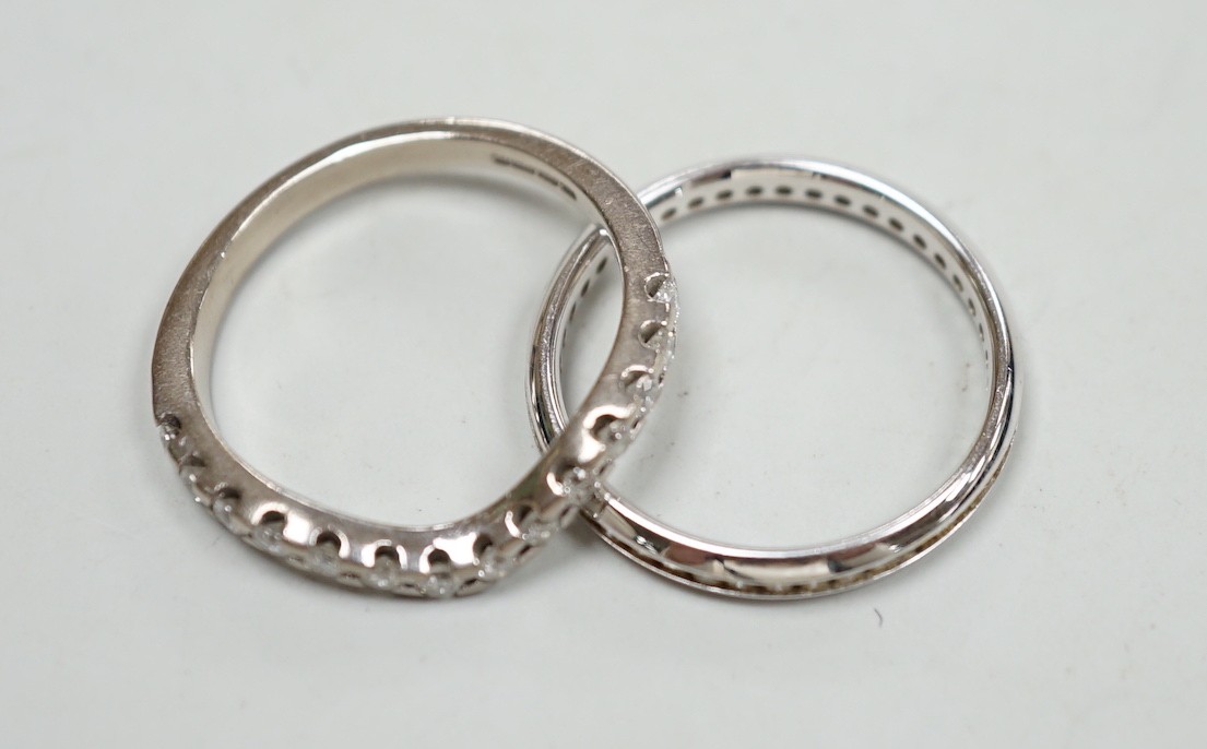 A modern 18ct white gold and diamond chip set full eternity ring, size O and a modern 18ct white gold and fourteen stone diamond chip set shaped half eternity ring, size O, gross weight 5.7 grams.
